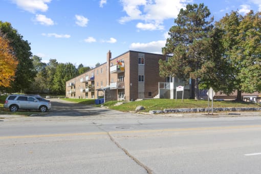 a brick apartment building with a car parked in front of it