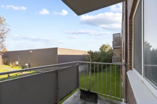 a balcony with a metal railing and a grassy area in the background