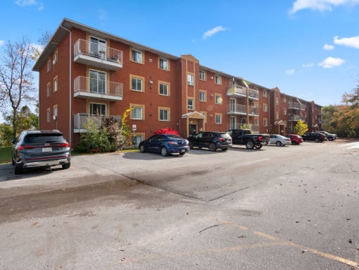 a parking lot in front of a brick apartment building