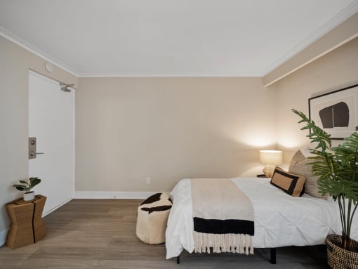a bedroom with a bed and a potted plant