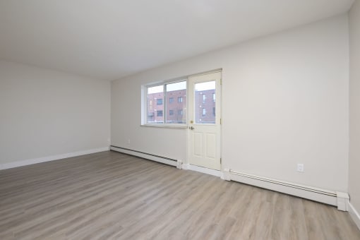 a bedroom with hardwood floors and white walls