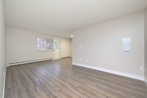 a bedroom with hardwood floors and white walls