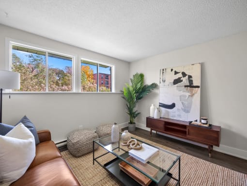 a living room with a glass coffee table and brown couch