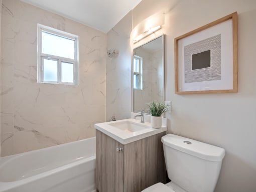 a bathroom with a toilet sink and bathtub in a 555 waverly unit