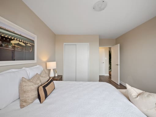 a bedroom with a large bed and a window with a view of the hallway