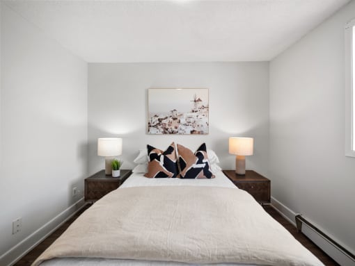 a bedroom with a bed and two night stands with lamps