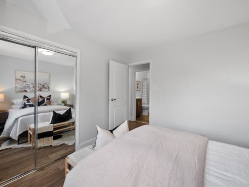 a bedroom with a large bed and a large mirror