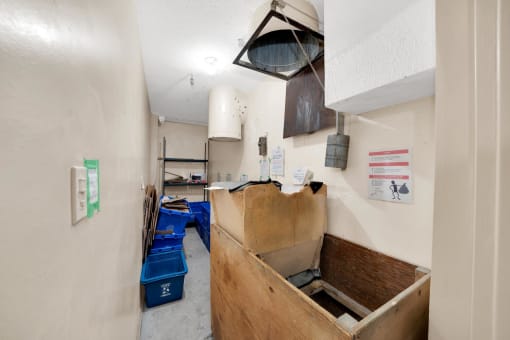 a large wooden box is in the corner of a room with white walls and concrete floors