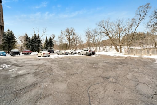 a parking lot in front of a building with snow on the ground
