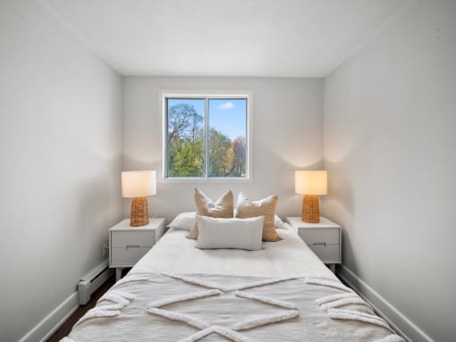 a bedroom with a large bed and two night stands with lamps