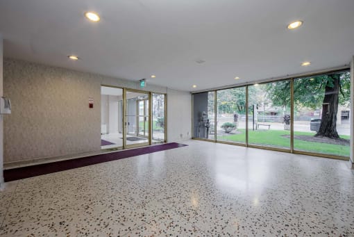 a large room with a large window and a purple rug on the floor
