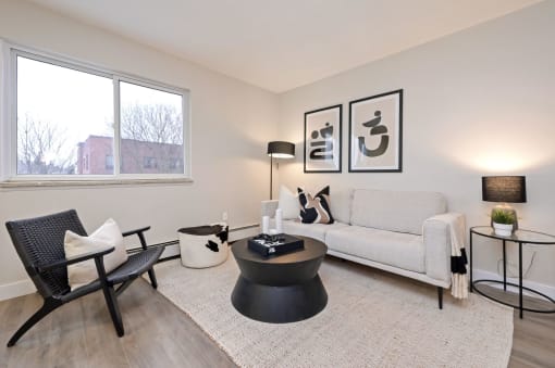 a living room with white walls and a large window