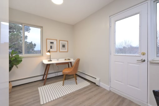 a home office with a desk and chair in the corner of a room
