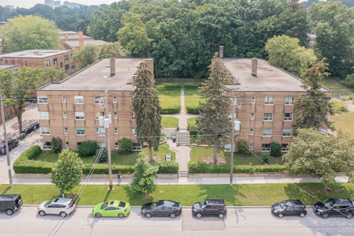 a view from above of a large brick building with cars parked in front of it