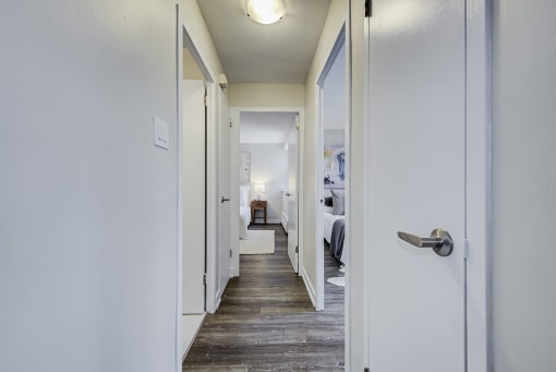 a hallway with white walls and a wooden floor