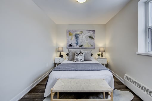 a bedroom with a large white bed and a large painting on the wall