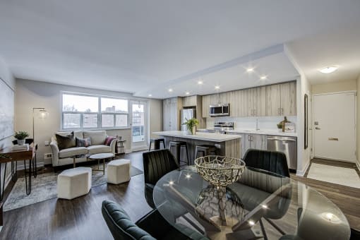 a living room and kitchen with a glass table and chairs