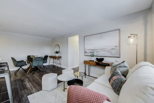 a living room with a white couch and a dining room table in the background