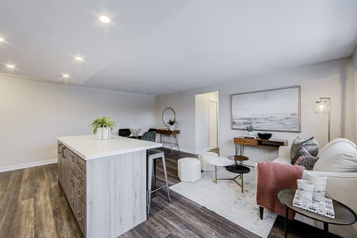a kitchen and living room with white walls and hardwood floors