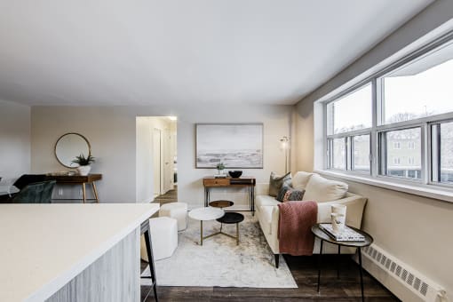 a living area with a couch coffee table and two windows