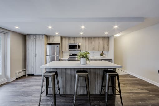 a kitchen with a large island with three stools in front of it