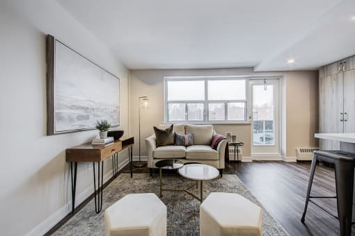 a living room with a couch coffee table and two stools