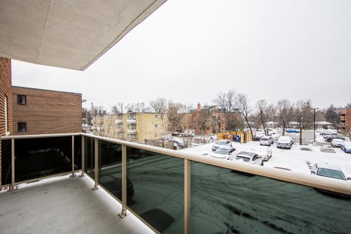 a balcony with a view of a parking lot and buildings in the distance