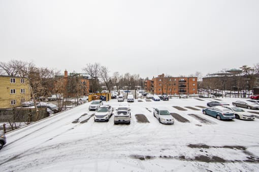 a snow covered parking lot in front of a brick building