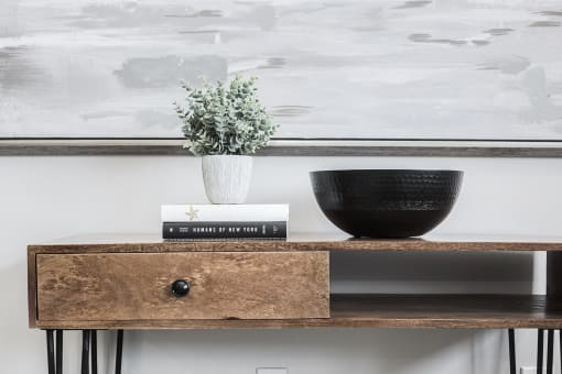 a wooden shelf with books and a vase on top