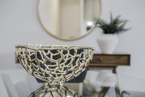 a bowl on a glass table in front of a mirror