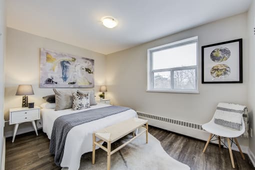a bedroom with a bed and a chair in a 555 waverly unit