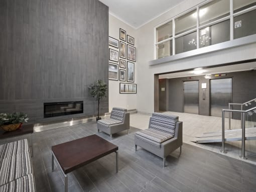 a seating area with two chairs and a coffee table in the lobby of a building