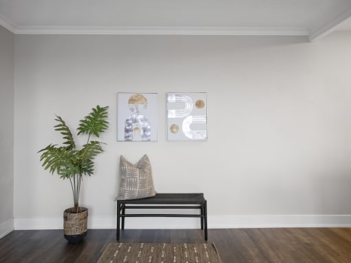 a seating area with a plant and artwork on the wall