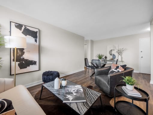 a living room with a couch coffee table and chairs and a dining room table in the background