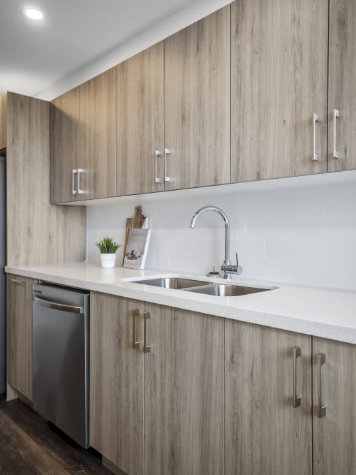 a kitchen with white countertops and wooden cabinets