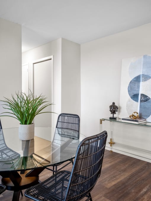 a dining room with a glass table and four chairs