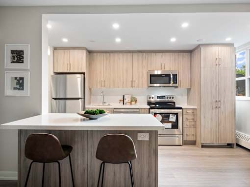 A modern kitchen with wooden cabinets and a white island.