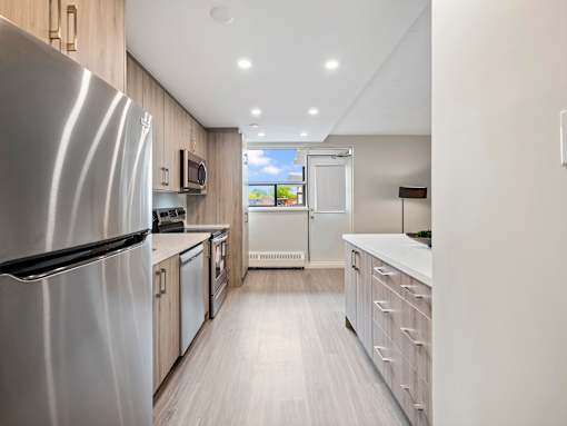 A modern kitchen with a refrigerator on the left and a counter on the right.