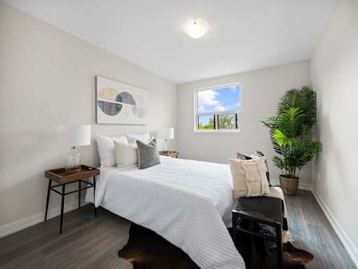 A bedroom with a large bed and a painting on the wall.