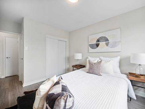 A bedroom with a large bed and a painting on the wall.