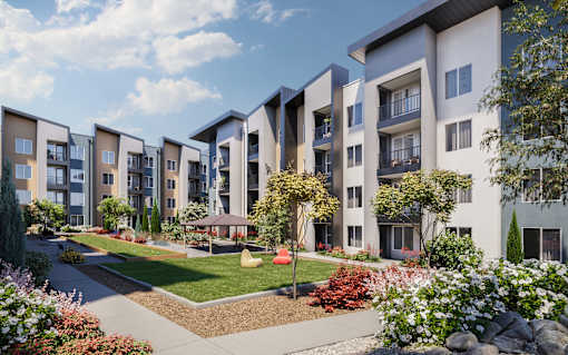 A row of modern apartment buildings with a landscaped garden in the foreground at The Village at Hawk View, Reno.