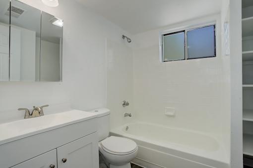 a bathroom with a toilet and a sink and a tub