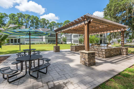 a picnic area with tables and umbrellas at the enclave at woodbridge apartments in sugar