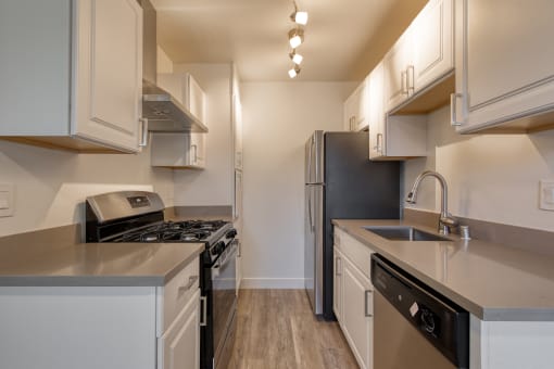 a kitchen with white cabinets and stainless steel appliances