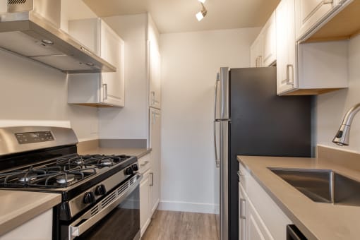 a kitchen with white cabinets and a black stove top oven