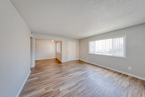 a bedroom with hardwood floors and a large window