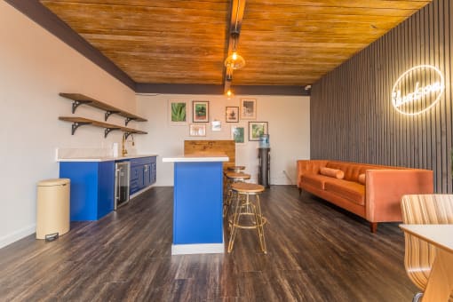 a room with a couch a kitchen and a bar