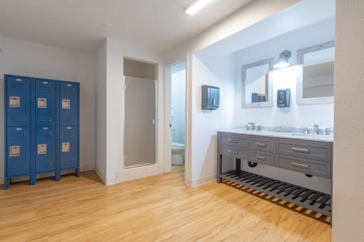 a bathroom with two sinks and two blue lockers