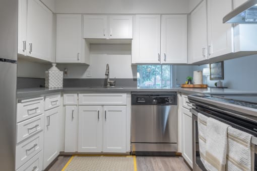 a kitchen with white cabinets and stainless steel appliances