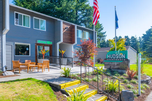 the front of the hudson apartments building with an american flag flying in front of